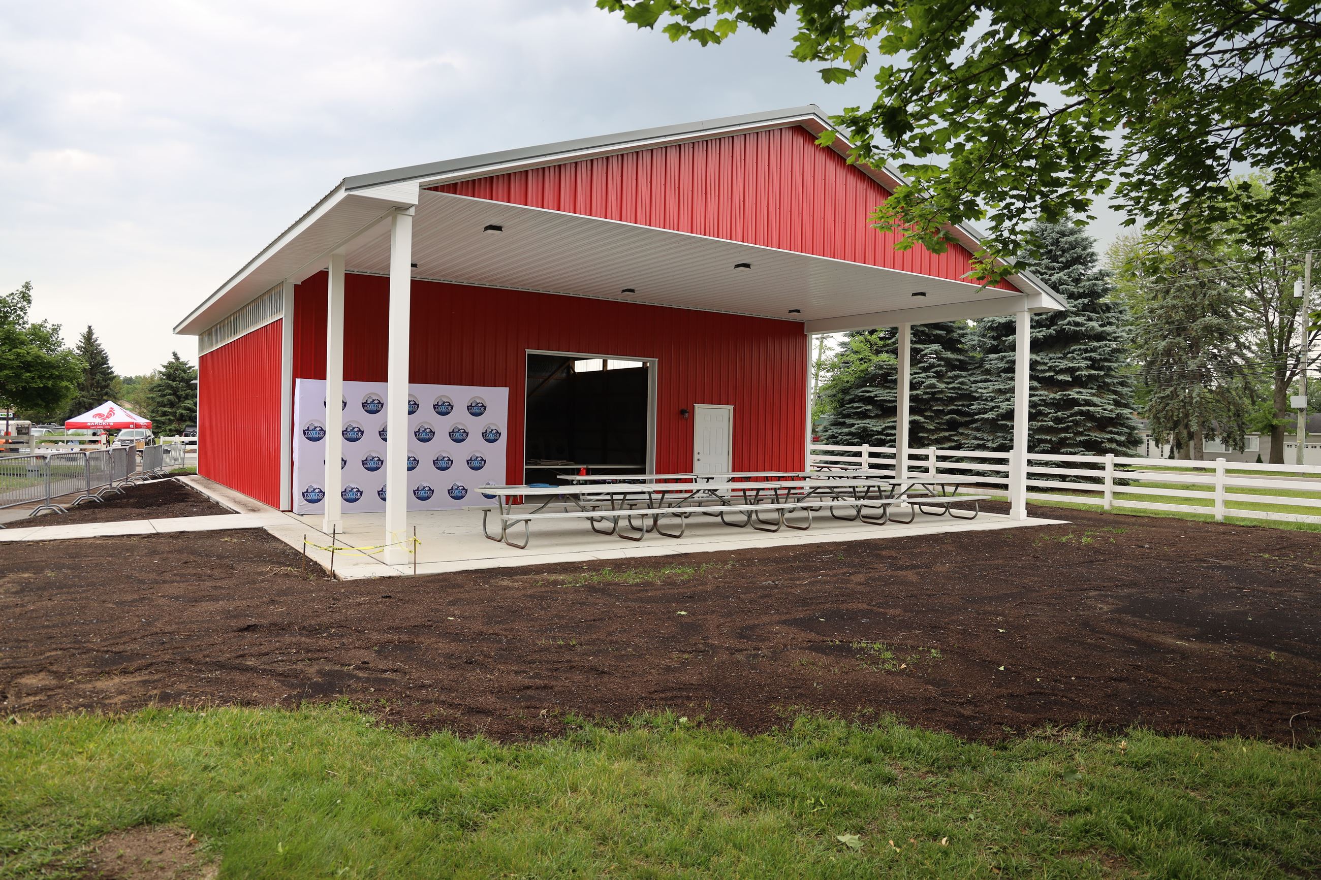 This is an exterior photo of the new red-and-white pavilion at the Petting Farm.