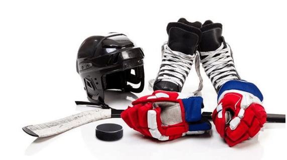 Stock photo of hockey equipment: skates, a stick, a helmet, and gloves. 