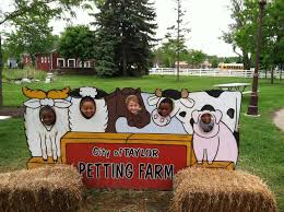 Group of children with their faces through a board cut out painted with animals